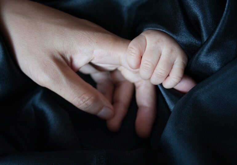 mano de un bebé y adulto