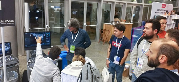 Foto Stand Medical Scan en el Congreso Nacional de Podología donde una persona examina una imagen en un ecógrafo ante una audiencia